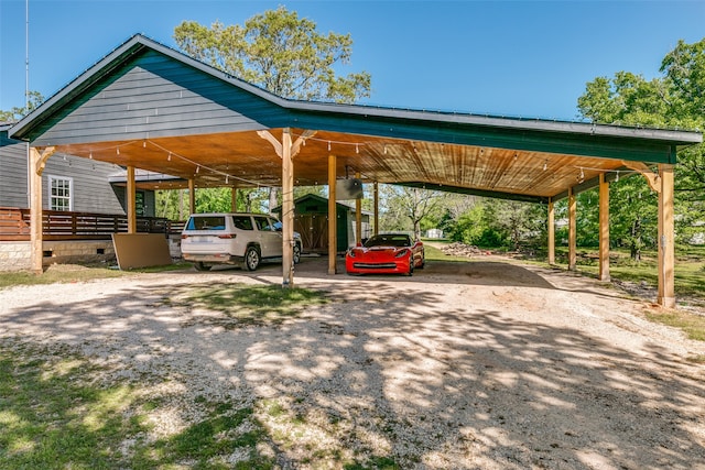 view of parking with driveway and a detached carport