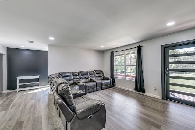 living room featuring visible vents, baseboards, wood finished floors, and recessed lighting