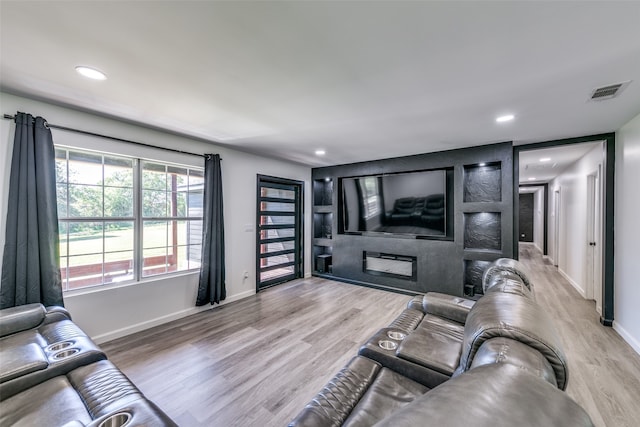 living room with recessed lighting, wood finished floors, visible vents, baseboards, and a glass covered fireplace