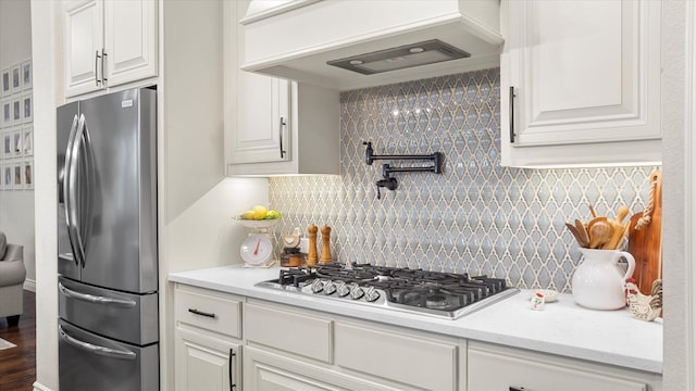 kitchen with backsplash, stainless steel appliances, white cabinetry, and custom exhaust hood