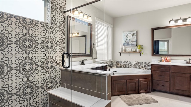 bathroom with tile patterned floors, vanity, and tiled bath