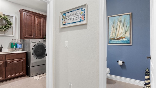 laundry area featuring sink, light tile patterned flooring, cabinets, and washer / dryer