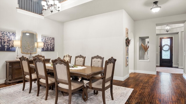 dining space with hardwood / wood-style flooring and a chandelier