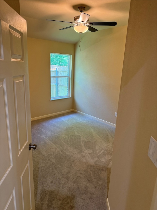 carpeted spare room featuring ceiling fan