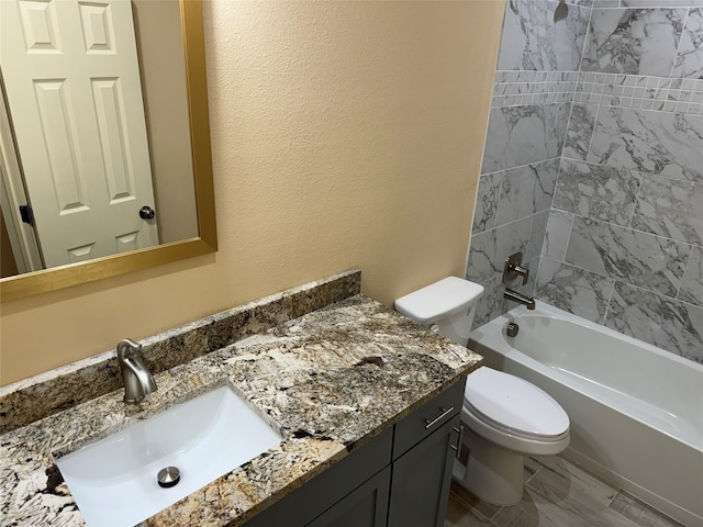 full bathroom with tiled shower / bath, vanity, and toilet