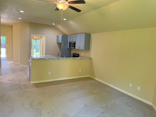 kitchen with kitchen peninsula, light colored carpet, and stove