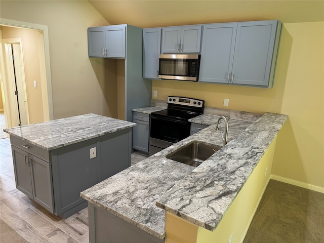 kitchen featuring kitchen peninsula, light carpet, light stone counters, sink, and appliances with stainless steel finishes