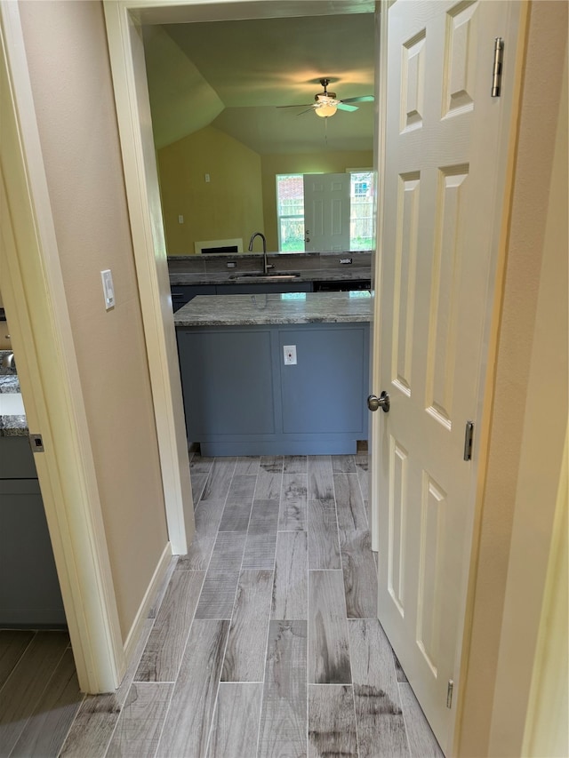 interior space with sink, light wood-type flooring, and lofted ceiling