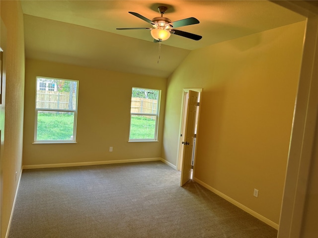 empty room with carpet, ceiling fan, a healthy amount of sunlight, and lofted ceiling