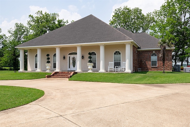 view of front facade with covered porch, central AC unit, and a front lawn