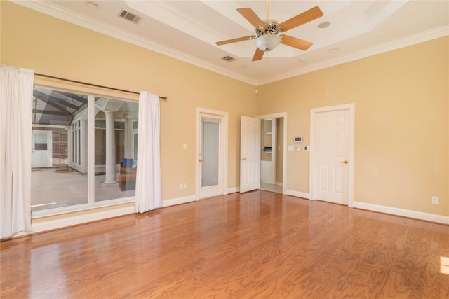 unfurnished room with ceiling fan, ornamental molding, a tray ceiling, and wood-type flooring