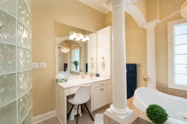 bathroom with tile patterned flooring, a bathing tub, decorative columns, and vanity