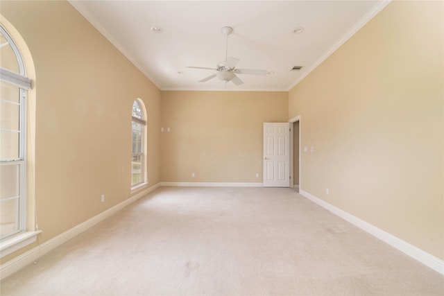 empty room with ceiling fan, crown molding, and light carpet