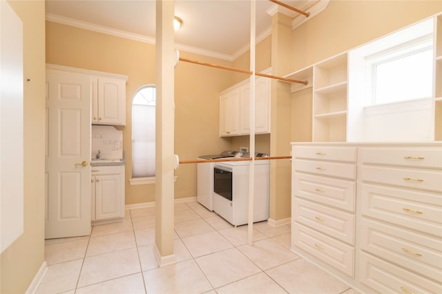 laundry area featuring ornamental molding, plenty of natural light, cabinets, washer and dryer, and light tile patterned floors