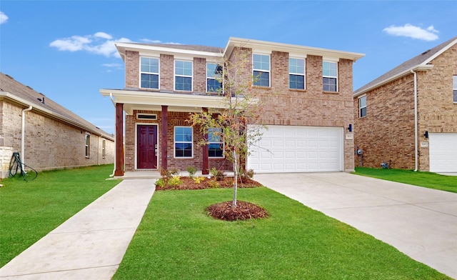 traditional home featuring a garage, a front yard, concrete driveway, and brick siding