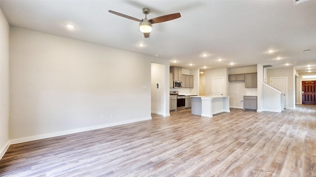 unfurnished living room with ceiling fan and light hardwood / wood-style flooring