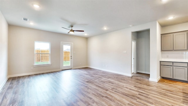 unfurnished living room with ceiling fan and light wood-type flooring