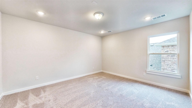 unfurnished room with light carpet, baseboards, and visible vents