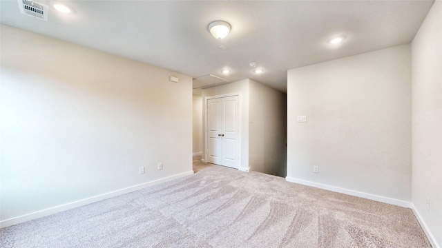 spare room featuring light colored carpet