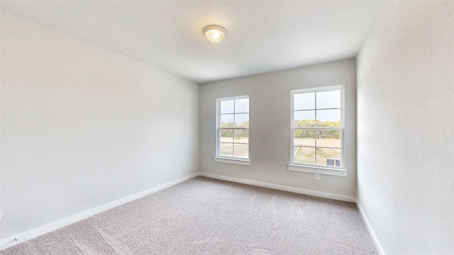 spare room with carpet and baseboards