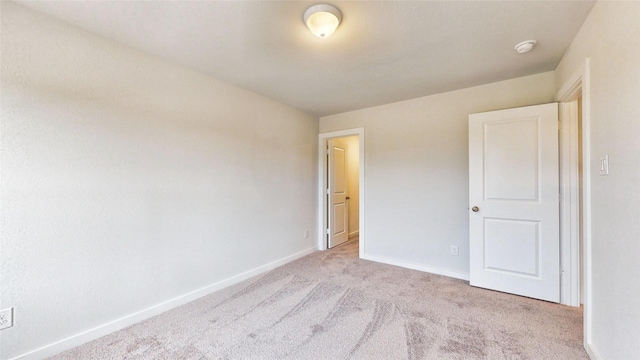 unfurnished bedroom featuring carpet flooring and baseboards