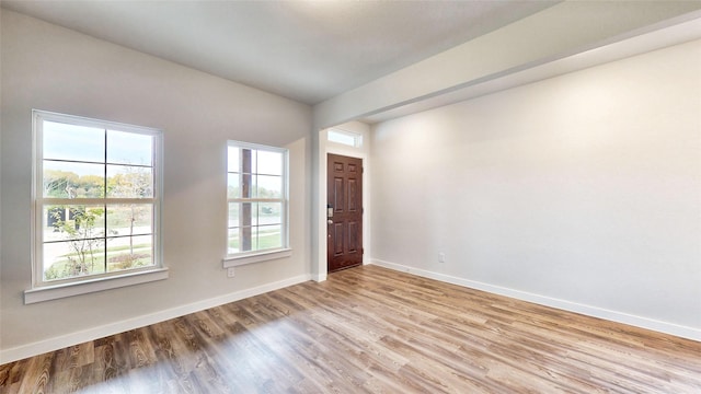 empty room with baseboards and wood finished floors