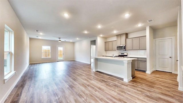 kitchen with light wood-style flooring, visible vents, stainless steel appliances, and gray cabinetry