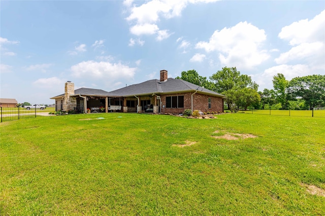 rear view of property with a lawn