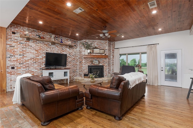 living room with a brick fireplace, light hardwood / wood-style floors, and wooden ceiling