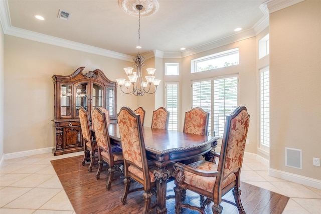 tiled dining room featuring ornamental molding and a chandelier