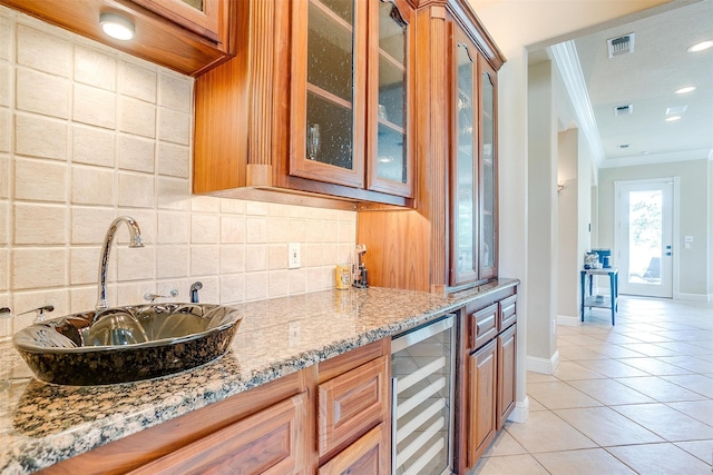 kitchen with light tile flooring, beverage cooler, tasteful backsplash, crown molding, and sink