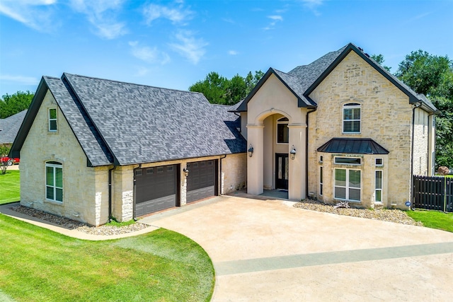 french provincial home featuring a garage and a front yard