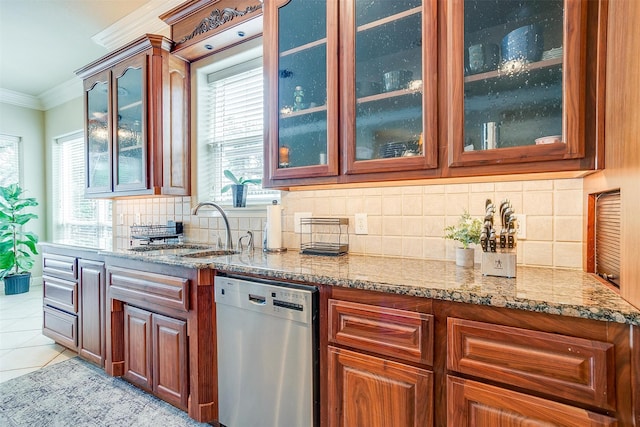 kitchen with a wealth of natural light, tasteful backsplash, dishwasher, and light tile floors