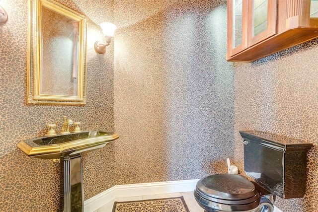 bathroom featuring tile flooring and toilet