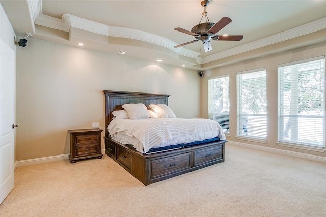 bedroom with light carpet, ceiling fan, a tray ceiling, and crown molding