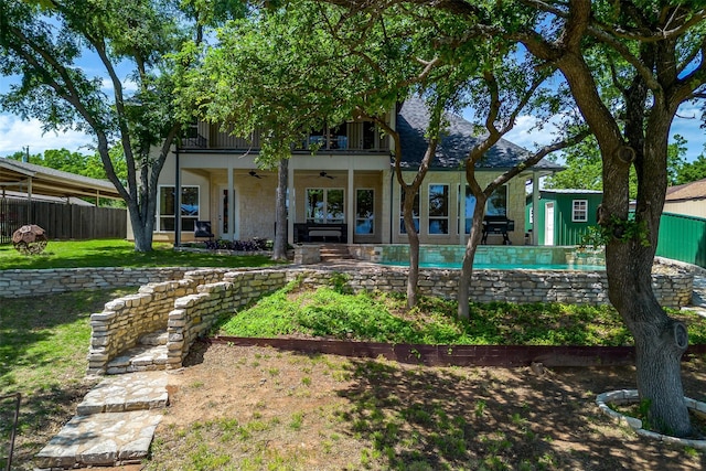 back of house with a balcony, a patio area, a yard, and ceiling fan