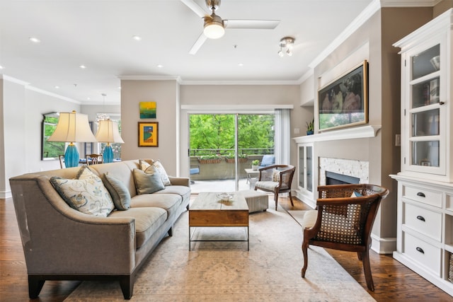 living room with ornamental molding, wood-type flooring, and ceiling fan