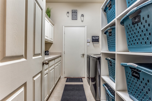 laundry area featuring washer and dryer, cabinets, and light tile patterned floors