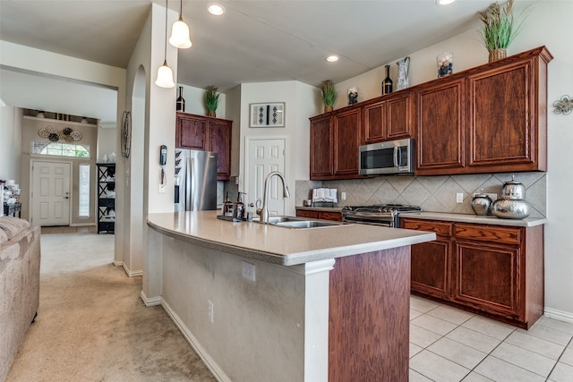 kitchen with light carpet, appliances with stainless steel finishes, decorative backsplash, sink, and hanging light fixtures