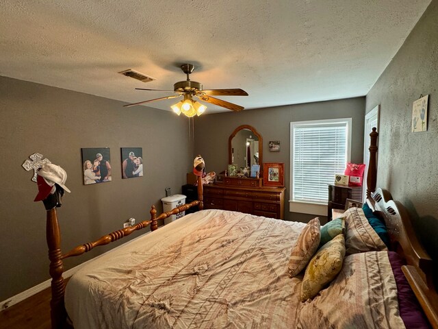 bedroom with ceiling fan and a textured ceiling