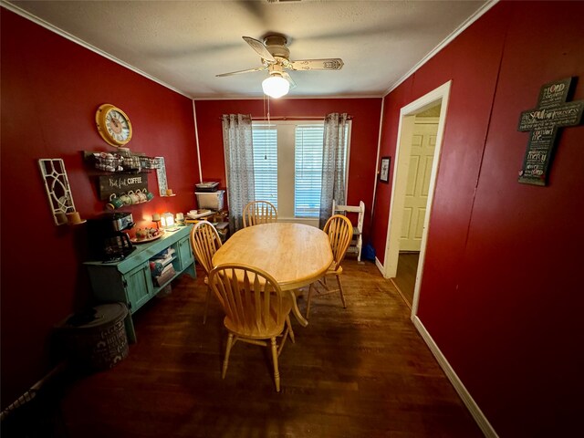 dining space featuring crown molding, dark wood-type flooring, and ceiling fan