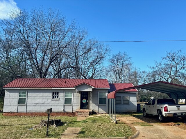 ranch-style home with a carport and a front lawn