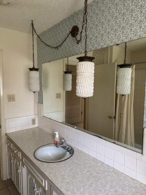 bathroom featuring a textured ceiling, vanity, and a shower with shower curtain