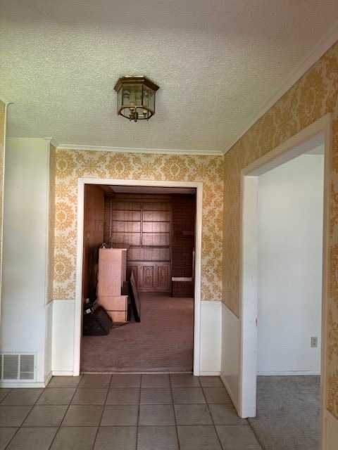 corridor with crown molding, carpet floors, and a textured ceiling