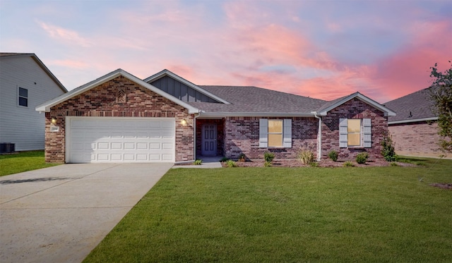 view of front of property with a garage, cooling unit, and a lawn