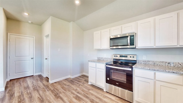 kitchen with light stone counters, light hardwood / wood-style floors, stainless steel appliances, and white cabinets