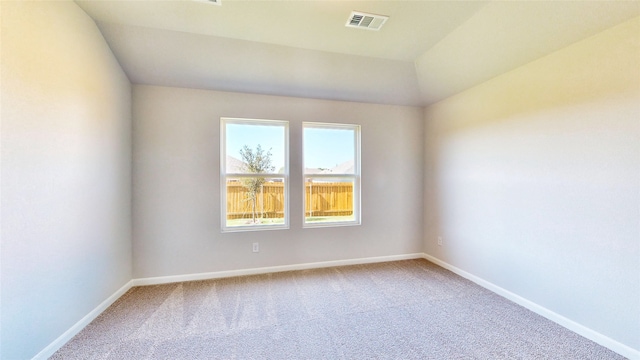 carpeted spare room with vaulted ceiling