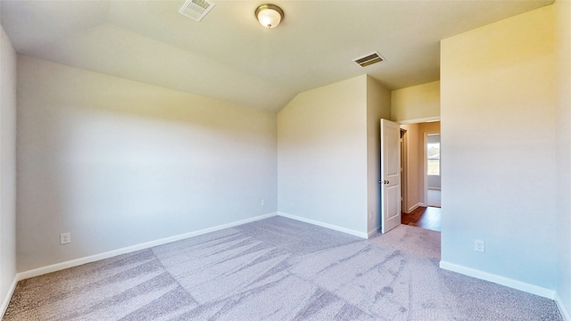 spare room with lofted ceiling and carpet flooring