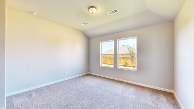 carpeted empty room with lofted ceiling