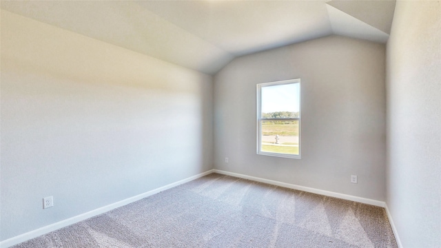 carpeted spare room with lofted ceiling